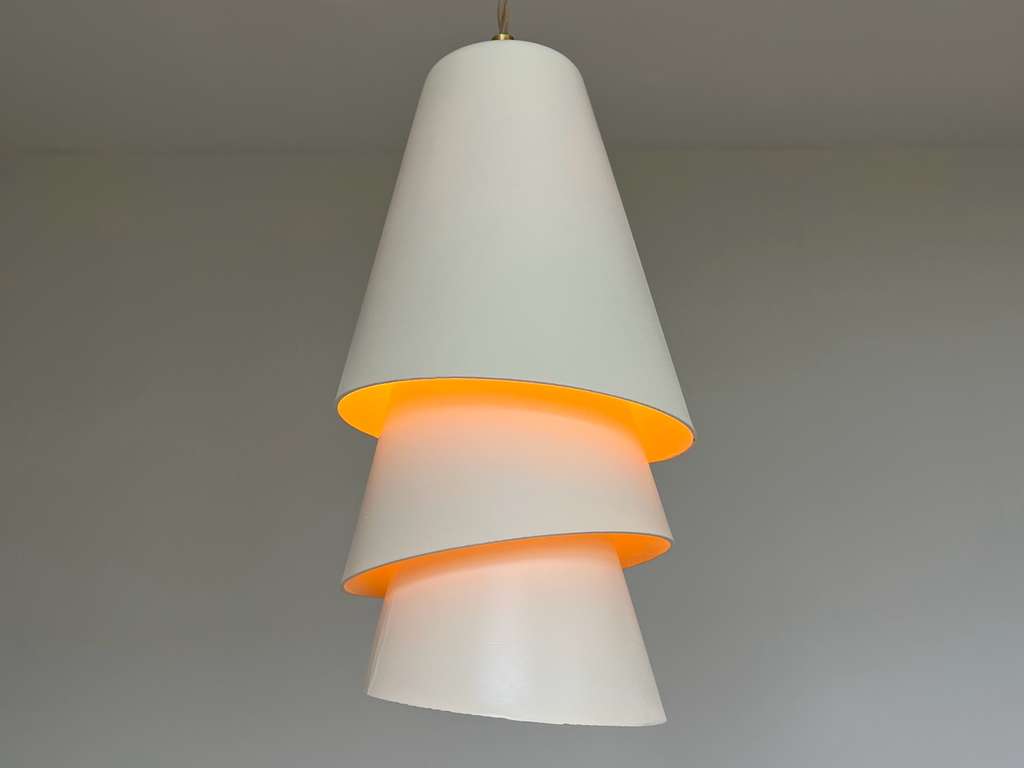 Blossom Pendant — layered white pendant lamp glowing warm amber through the gaps between its shades